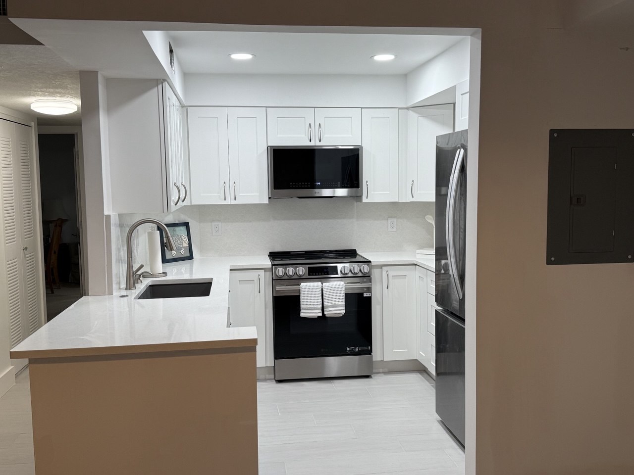 Completed Marco Island kitchen renovation with white shaker cabinets and stainless steel appliances